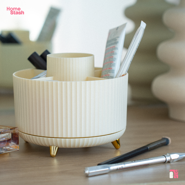 Makeup brush organizer with multiple compartments, neatly storing brushes, lipsticks, and beauty tools on a marble countertop.