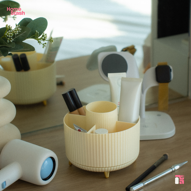 Round and white makeup organizer on a wooden countertop surrounded by various beauty and makeup products.