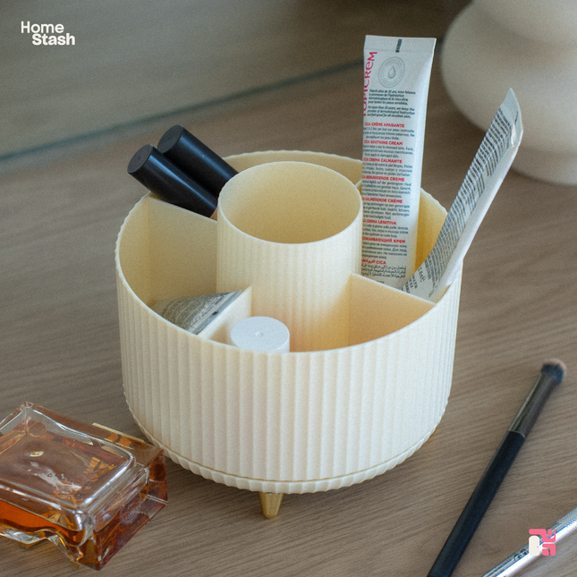 Top view of a white round makeup organizer, with a rotating swivel mechanism, makeup neatly stored inside it's compartments. 